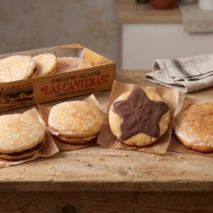 Pack Degustación de tortas de Alcázar Las Canteras: estuche y distintas variedades de torta sobre una mesa de madera